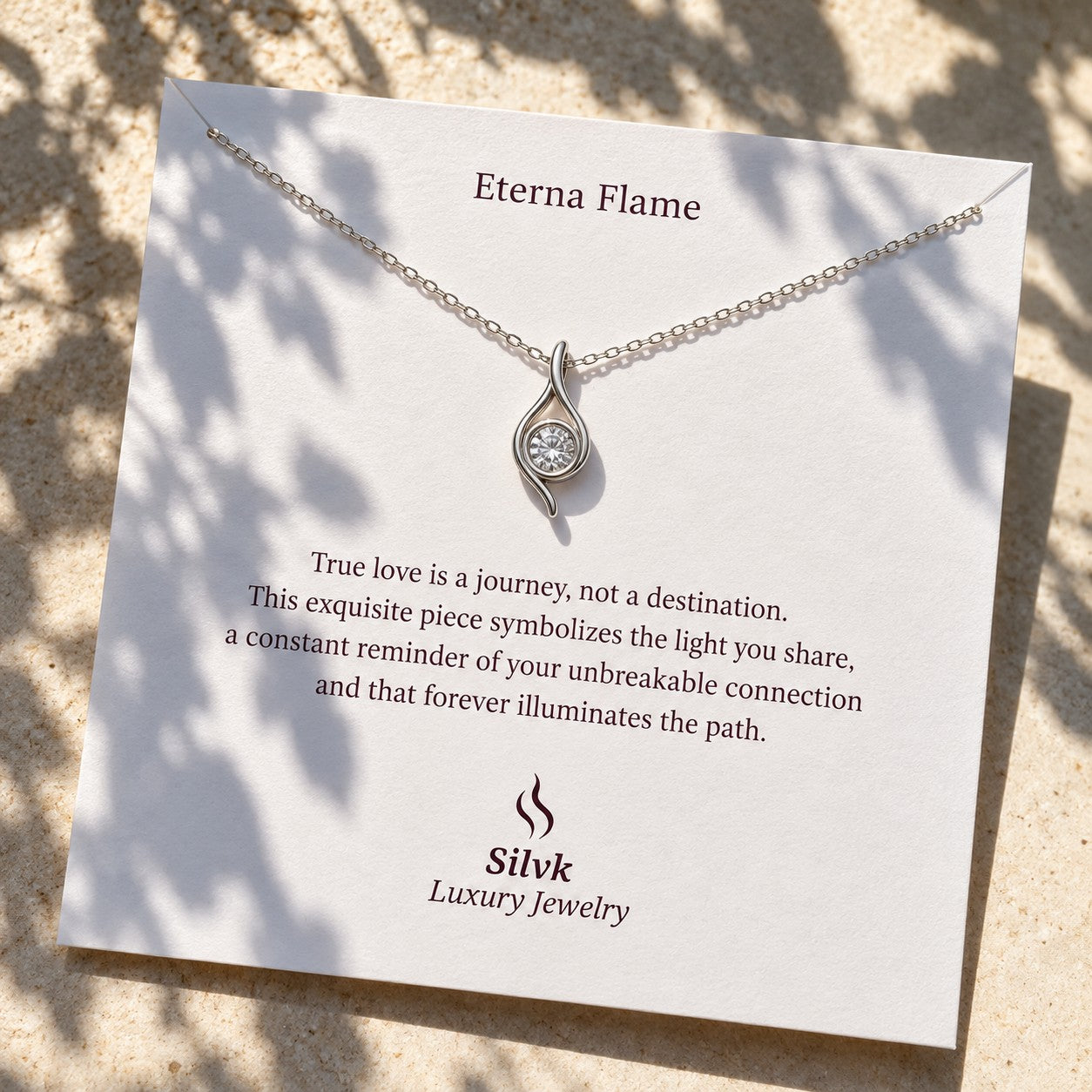 Eterna Flame pendant on its message card in sunlight, Silvk 925 silver jewellery