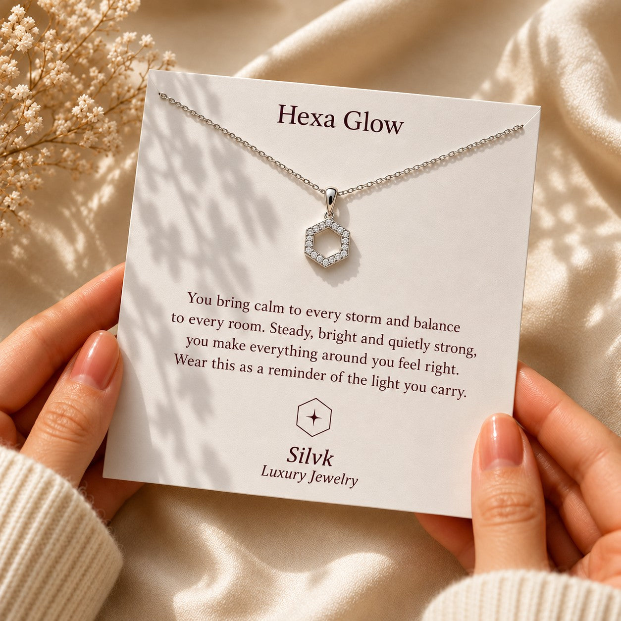 Hexa Glow pendant on its message card held in two hands, Silvk 925 silver jewellery