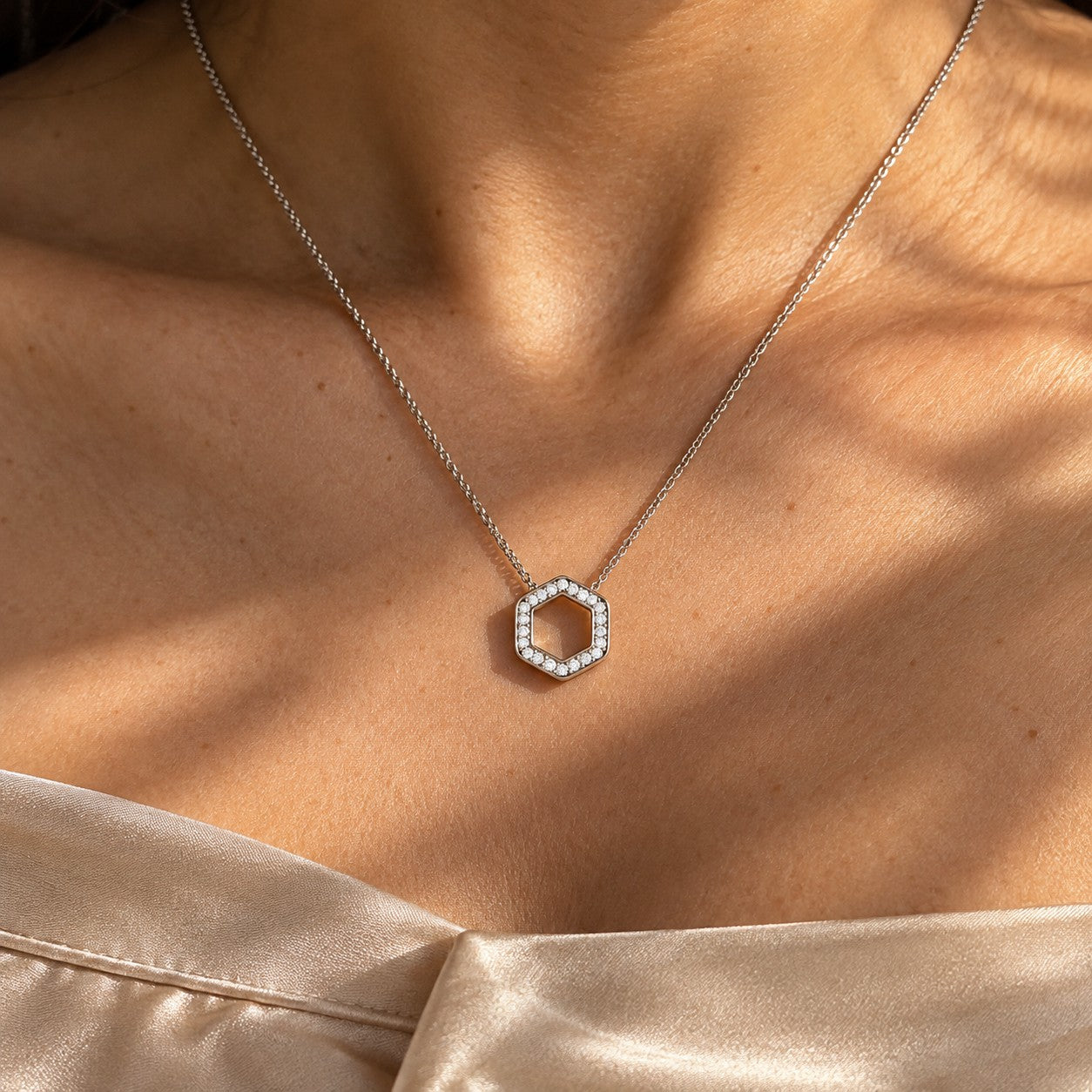 The Hexa Glow silver hexagon pendant worn on the neck in sunlight, Silvk 925 silver jewellery