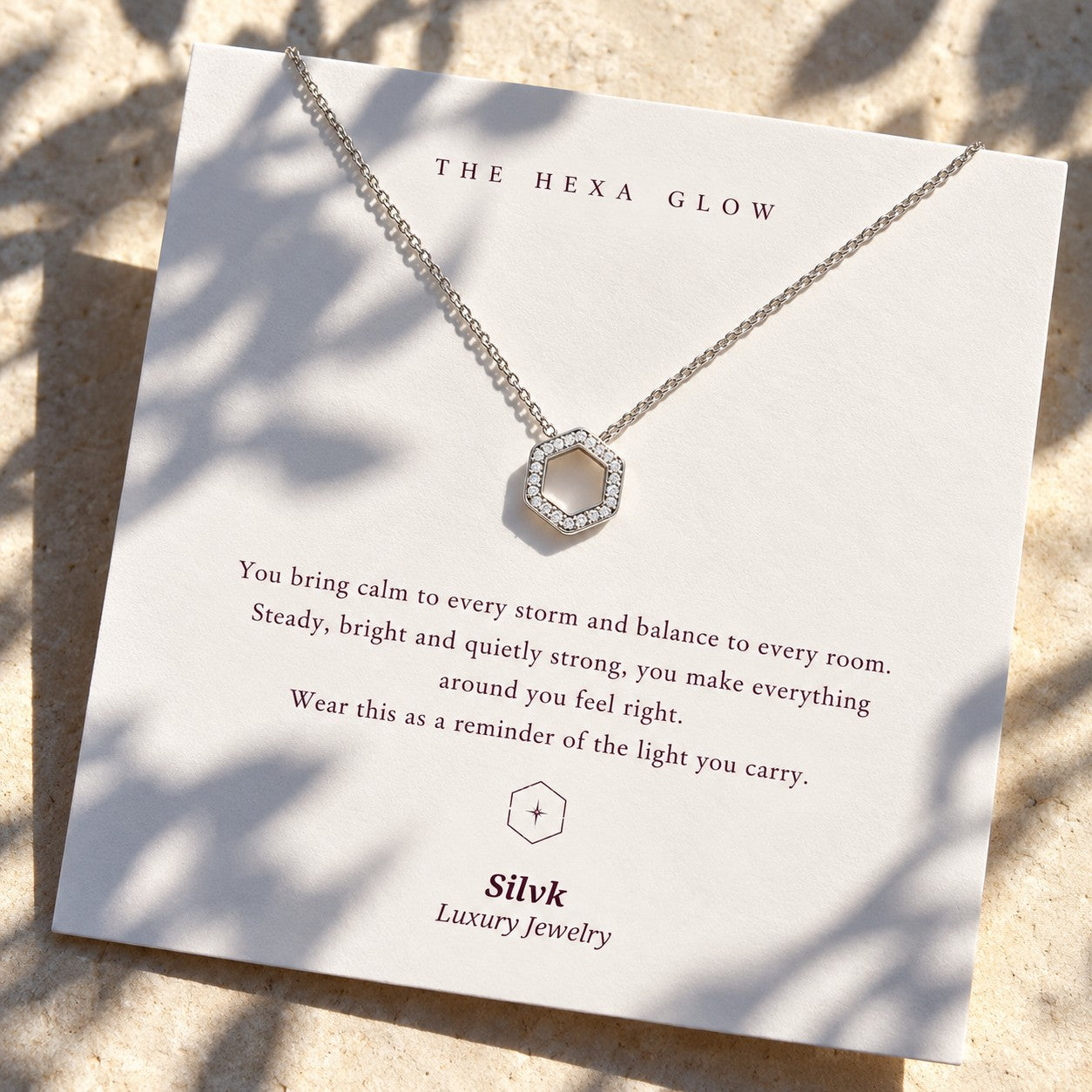 The Hexa Glow pendant on its message card in sunlight, Silvk 925 silver jewellery