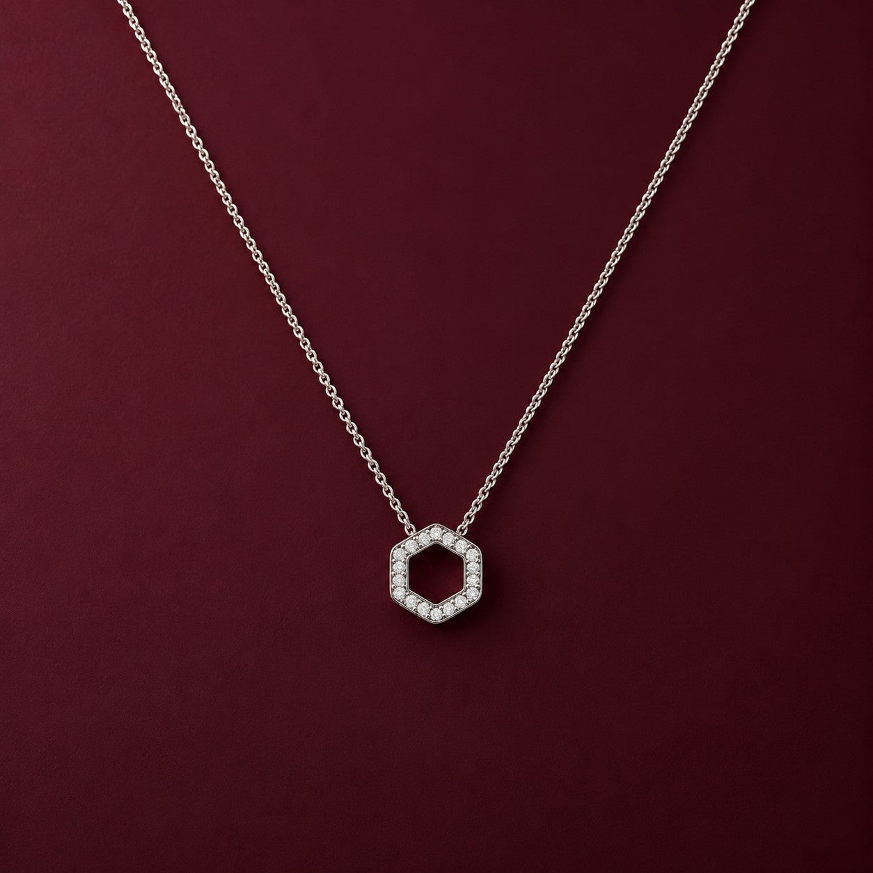The Hexa Glow silver pendant on a deep burgundy background, Silvk 925 silver jewellery