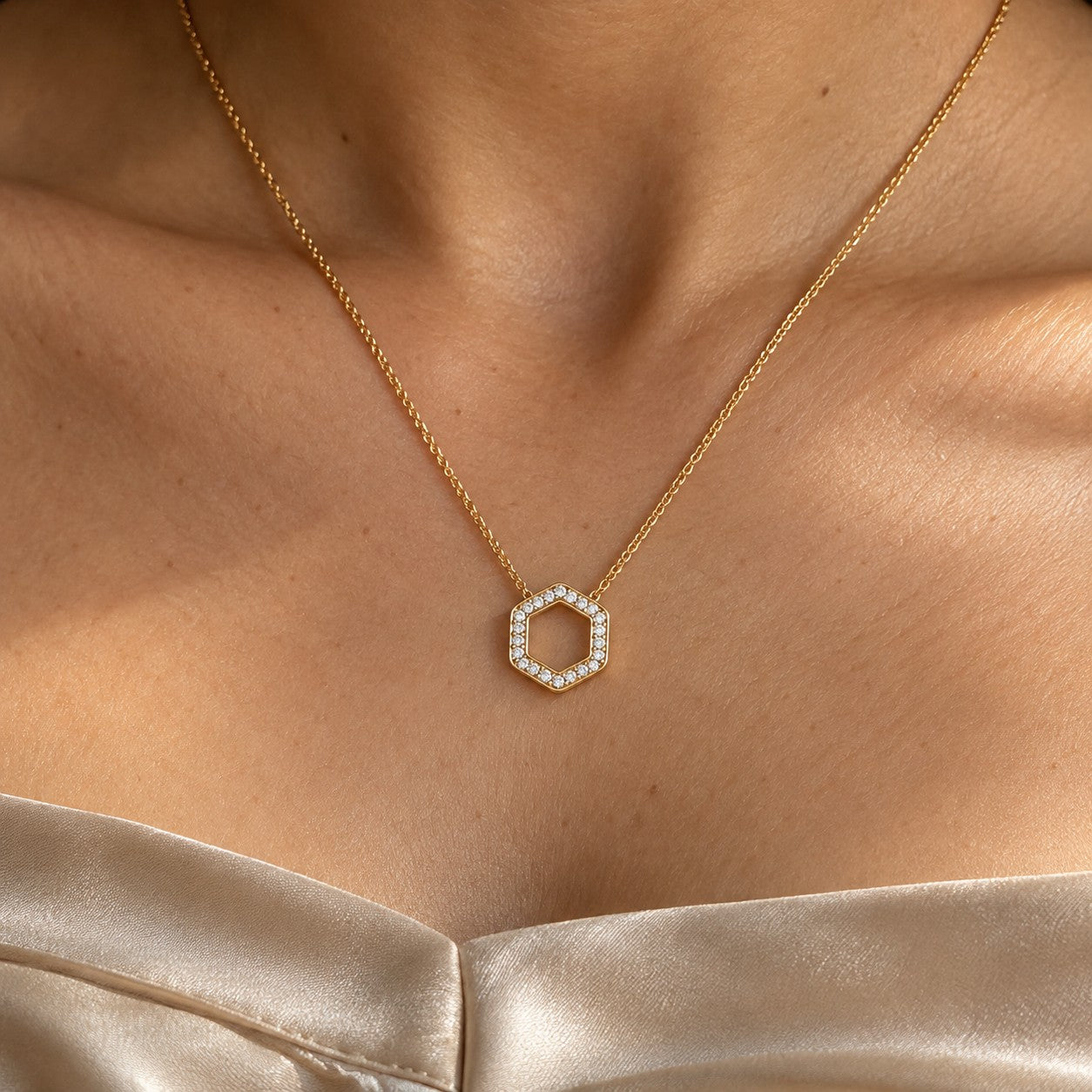 The Hexa Glow gold hexagon pendant worn on the neck in sunlight, Silvk 925 silver jewellery