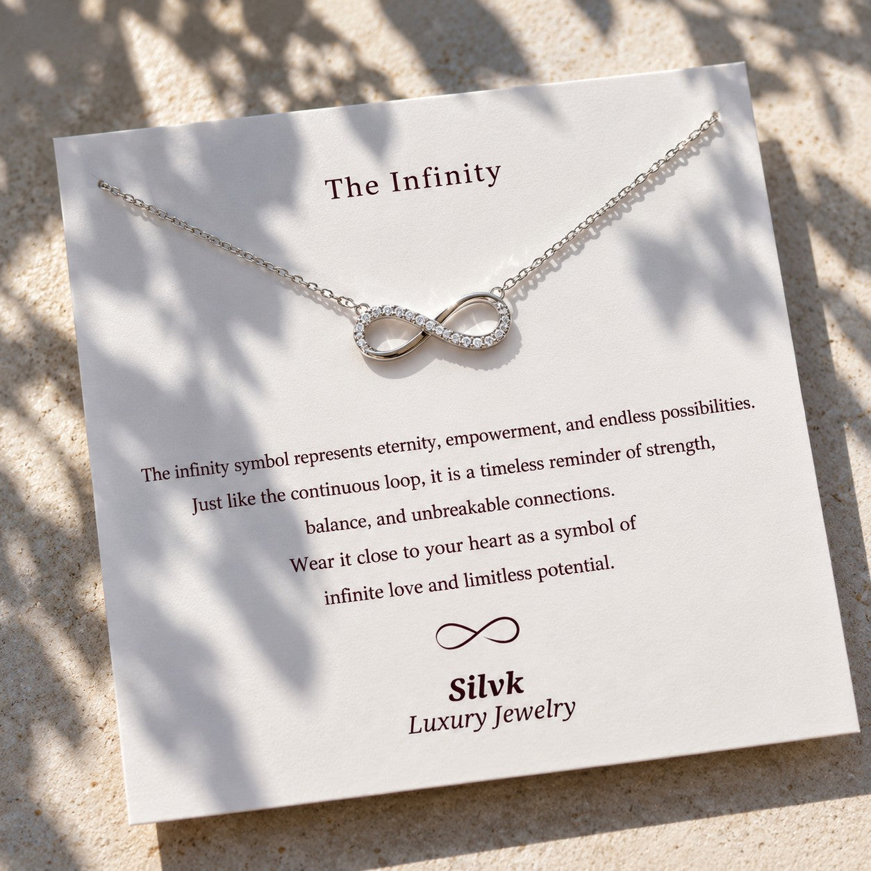 The Infinity pendant on its message card in sunlight, Silvk 925 silver jewellery