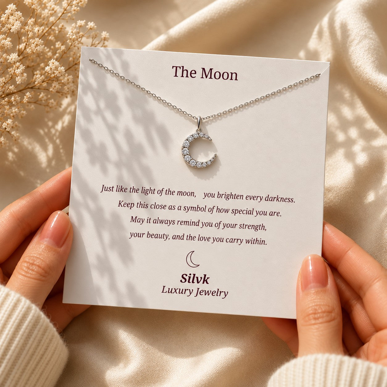 The Moon pendant on its message card held in two hands, Silvk 925 silver jewellery