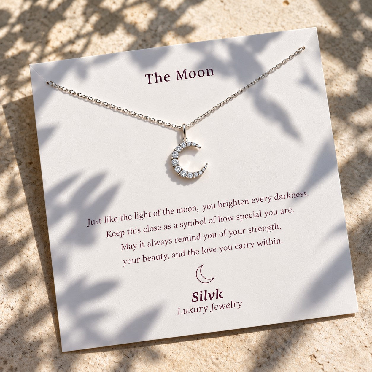The Moon pendant on its message card in sunlight, Silvk 925 silver jewellery