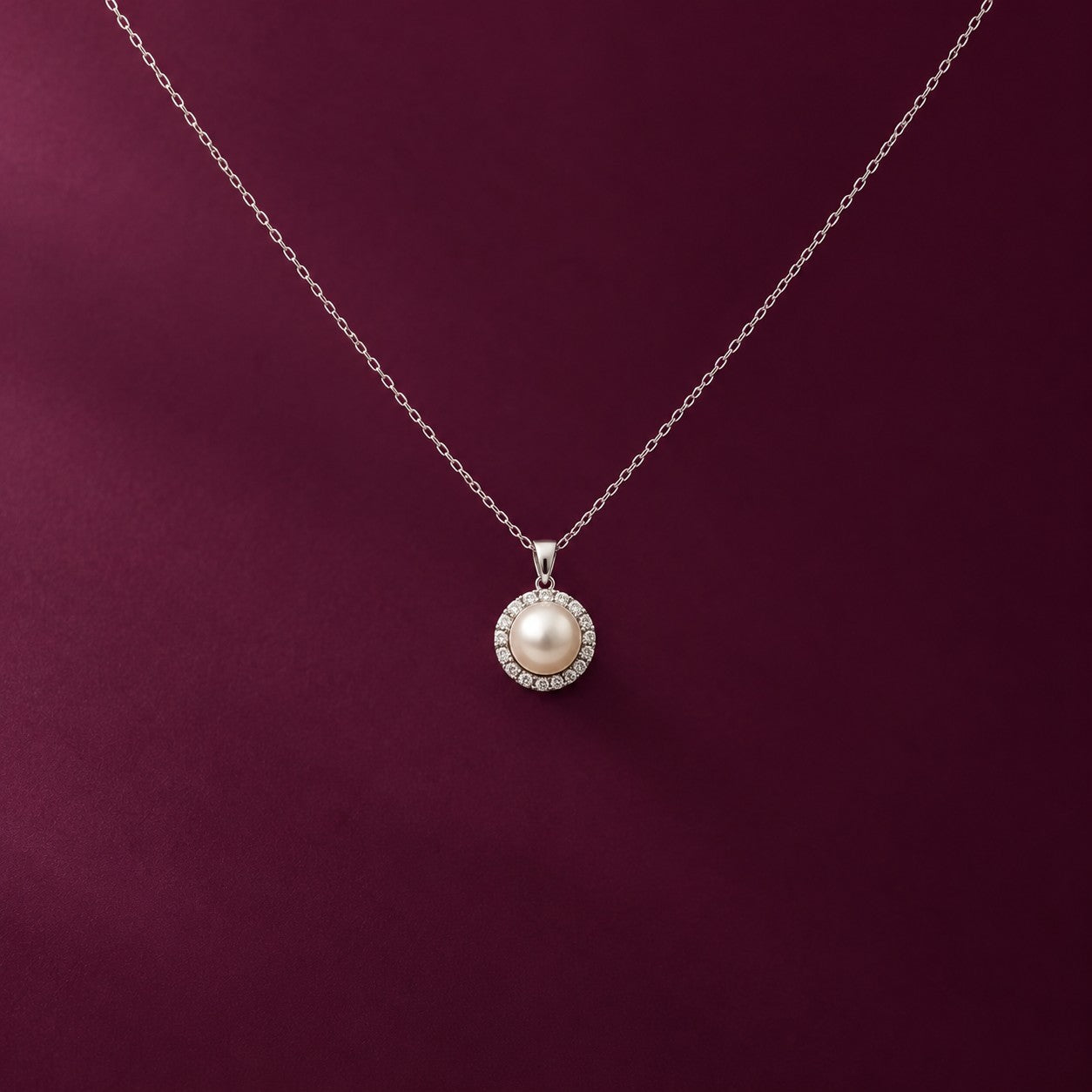 The Ocean Pearl silver pearl pendant on a deep burgundy background, Silvk 925 silver jewellery