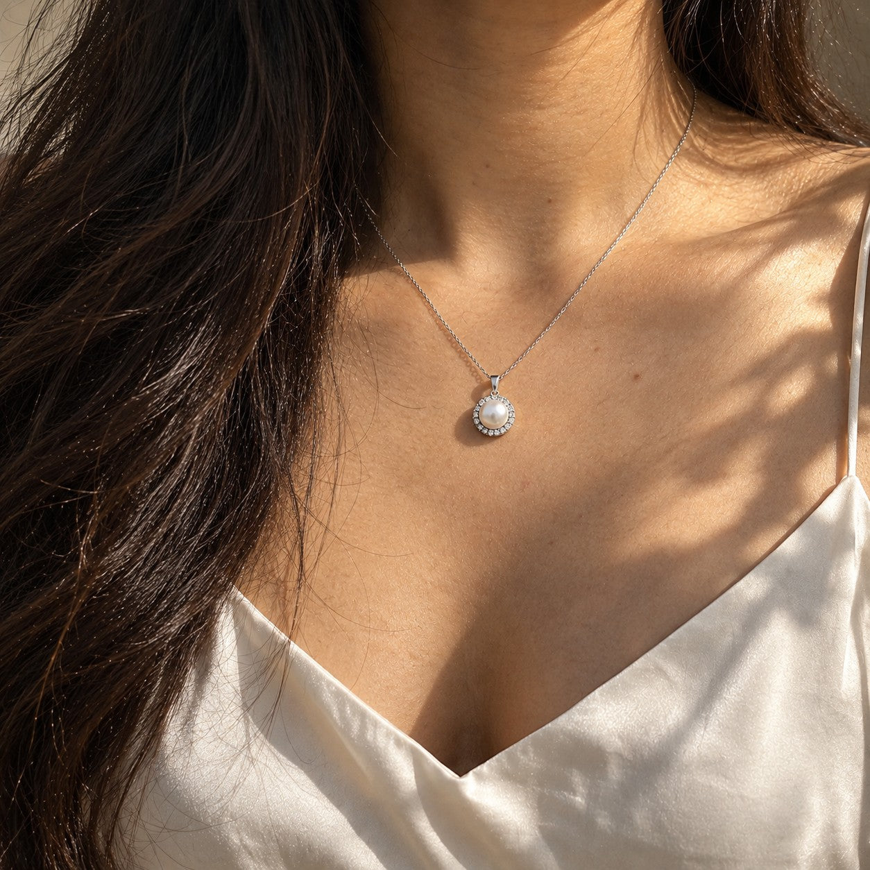 The Ocean Pearl silver pearl pendant worn on the neck with an ivory silk camisole, Silvk 925 silver jewellery